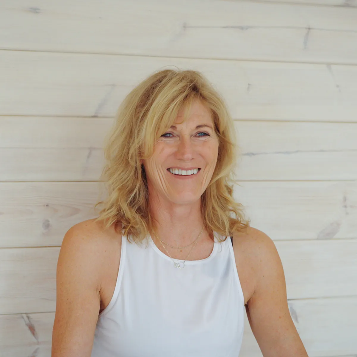 Sue Brown smiling in her wooden garden studio